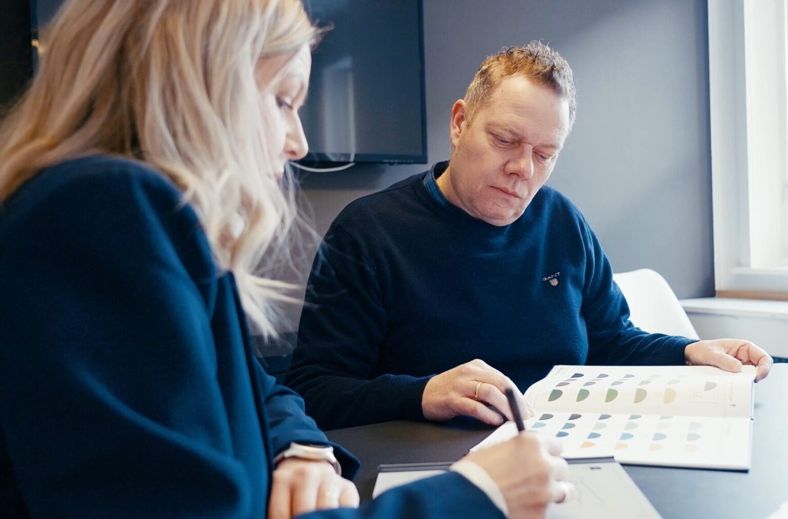 Grafiker anvender farveguiden sammen med kunden